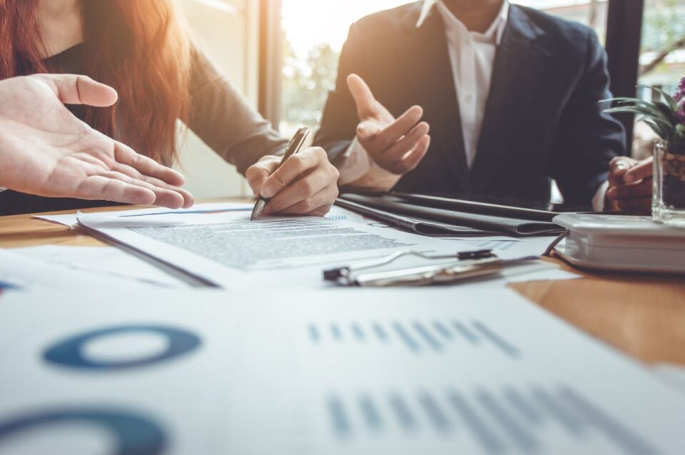 People sitting at a table signing a contract